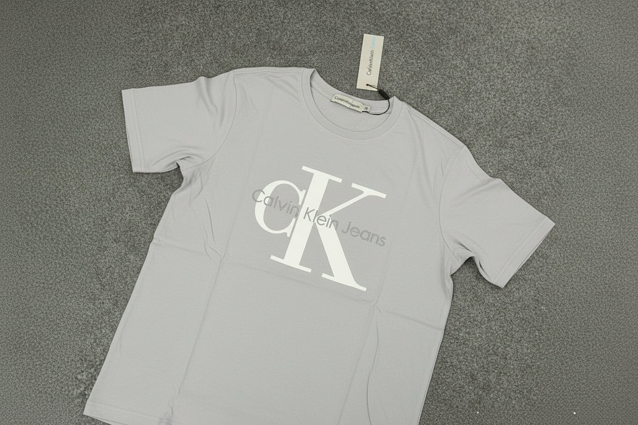 Product Title
Calvin Klein CK Monogram T-Shirt in Grey
 Iconic minimalism, timeless appeal
Product Description
The quintessential Calvin Klein signature. This CK monogram tee embodies American minimalist design philosophy—clean lines, iconic branding, and uncompromising quality in 100% premium cotton.
The Detail
Fabric: 100% premium cotton, sourced and manufactured in Portugal
Design: Signature CK monogram logo in classic placement
Philosophy: Less is more—iconic branding without excess
Fit: Modern regular 